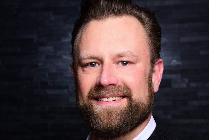Markus Gries wird neuer Publisher Wassersport bei Delius Klasing Mann mit Vollbart, trägt schwarzen Anzug und weißes Hemd